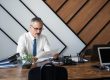 Professional man reviewing documents at a modern office desk.